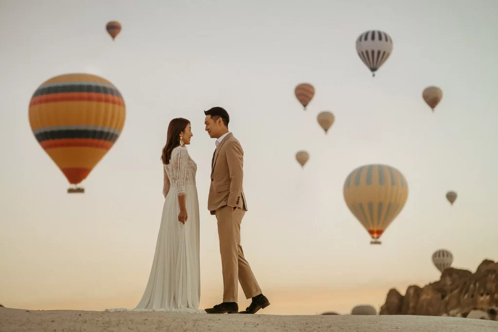 in cappadocia bride and groom looking each other under the hot air balloons